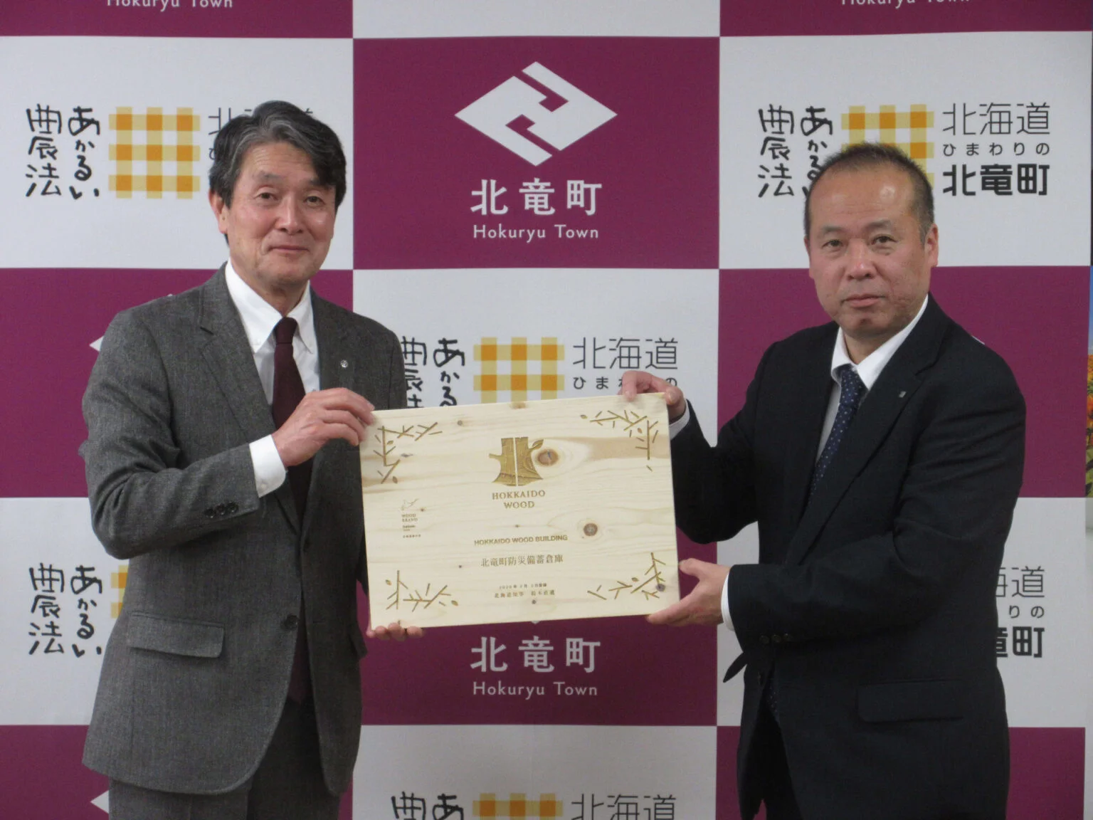 北竜町防災備蓄倉庫が北海道の実施する「ＨＯＫＫＡＩＤＯ ＷＯＯＤ ＢＵＩＬＤＩＮＧ」に登録され、３月５日、すこやかセンターにて北海道空知総合振興局長より木製の登録証が交付さた様子